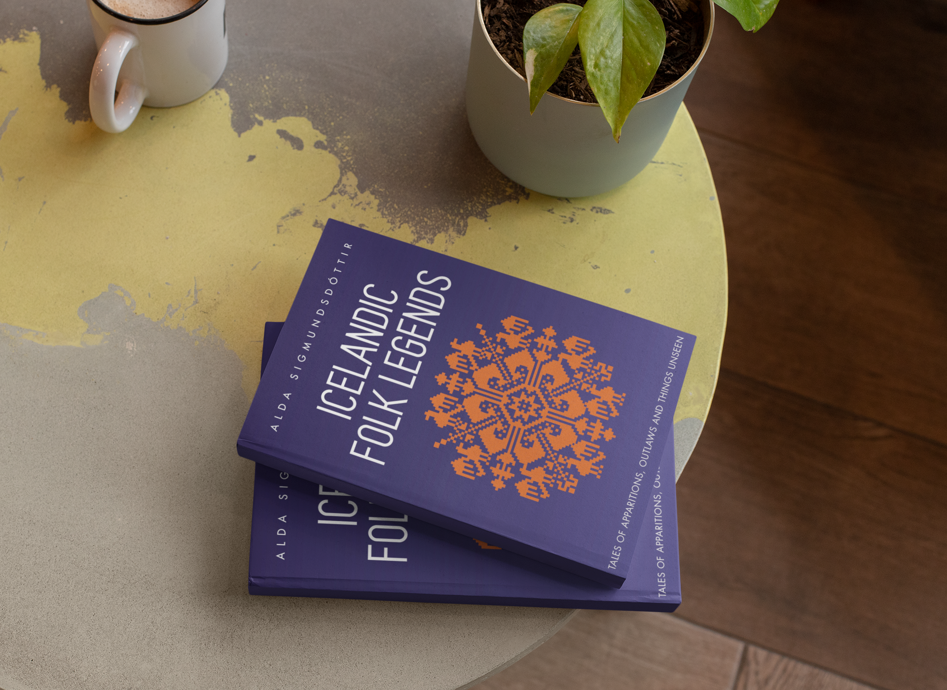 Two copies of Icelandic Folk Legends lying on a table next to a plant